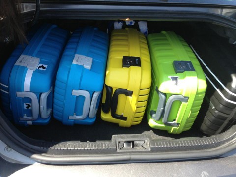 mid sized sedan rental car with 5 delsey carry on luggage in trunk