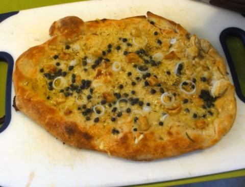 amh pizza with garden onions gruyere, capers and roasted garlic