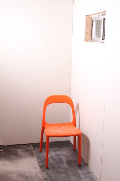 lonely orange chair meets drywall